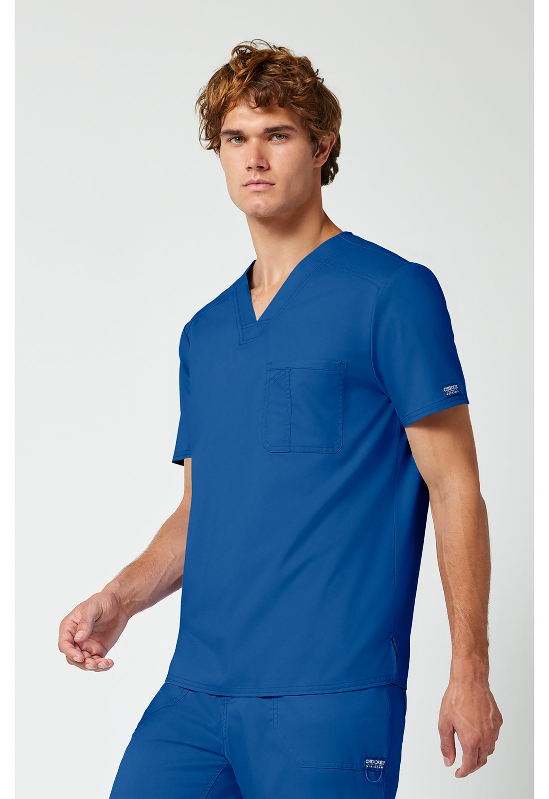Blusa cirúrgica masculina Cherokee Workwear Revolution com 1 bolso, gola em V e para dentro | Logo NYC Health + Hospitals | Enfermagem